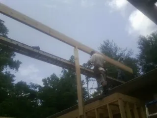 Carpenter setting a ridge beam over a new addition frame — Ice Dam Removal by Roofing Brothers in Glenwood Springs