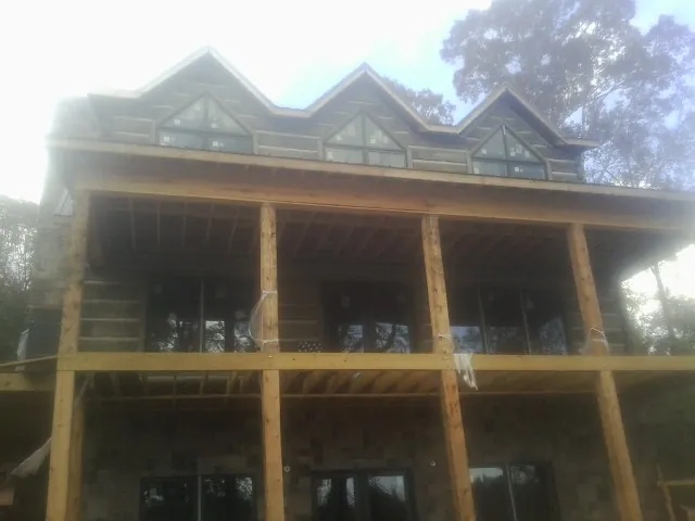 Dormers and porch framing on a large log home under construction — Roof Coating work by our crew in Glenwood Springs