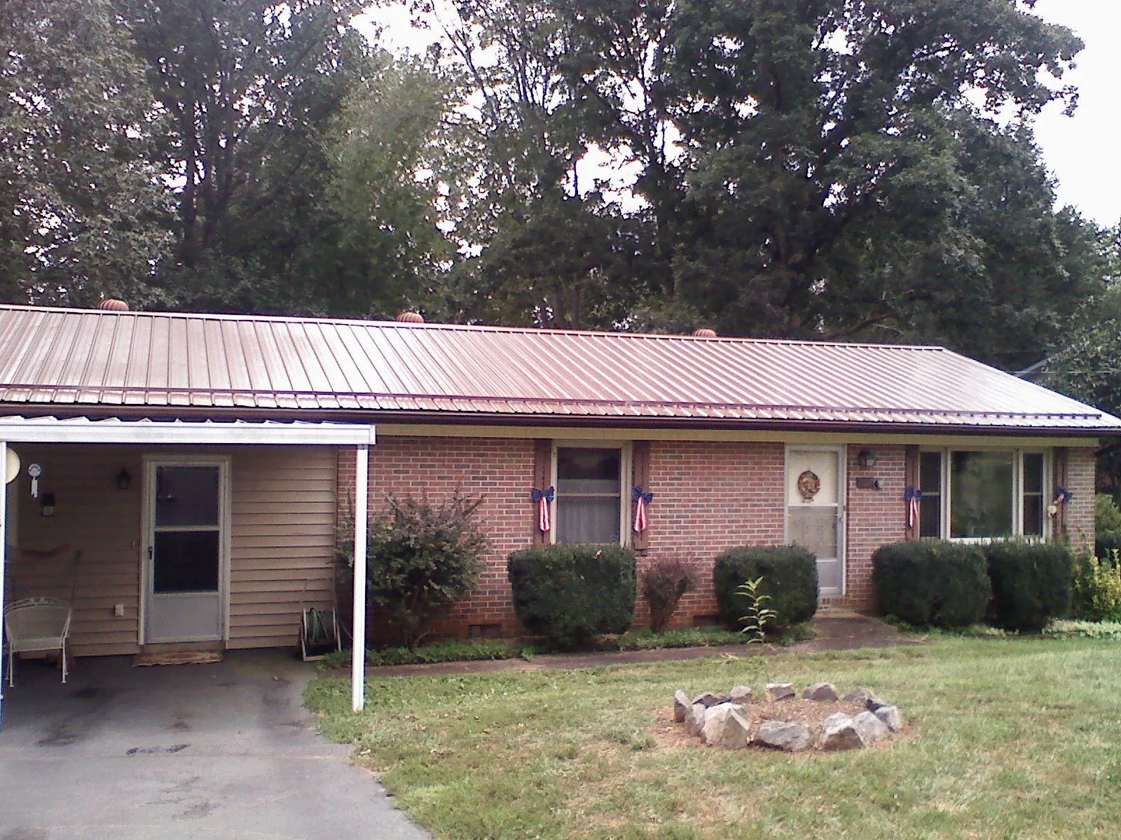 Bronze metal roof and carport on a brick ranch home — Roof Repair work by our crew in Glenwood Springs